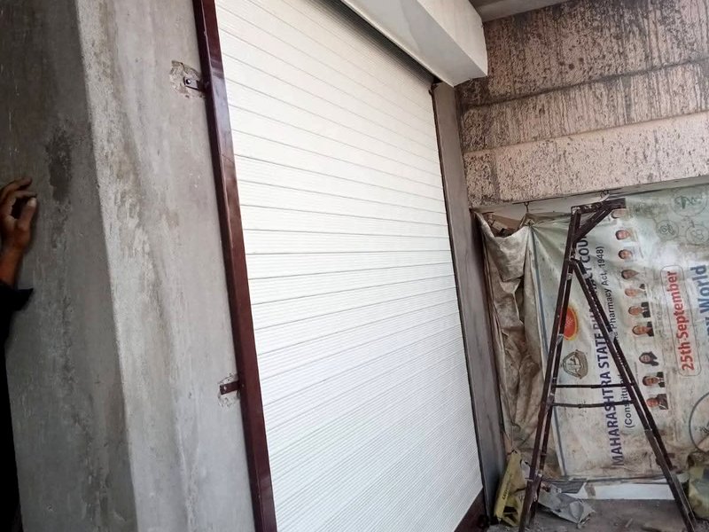 White rolling shutter brown frame ke saath — shop installation Nagpur